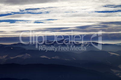 Silhouettes of cloudy mountains in evening