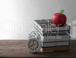 books with alarm and red Apple