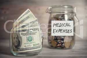 Dollars and coins in jar with medical expenses label