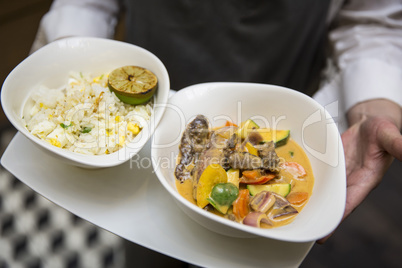 Gelbes Currygericht mit Reis / Bedienung Restaurant