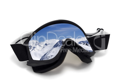 Ski goggles with reflection of mountains at sun day