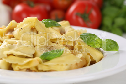Italienische Nudeln Tortellini mit Tomaten und Basilikum auf Tel