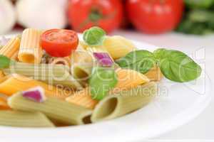 Bunte Penne Rigate Nudeln Pasta mit Tomaten und Basilikum auf Te