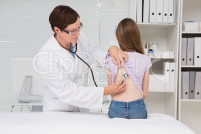 Doctor examining little girl