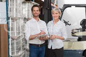 Smiling warehouse managers looking at camera