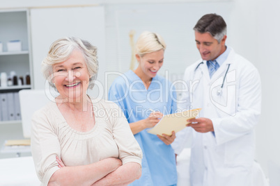 Patient smiling while doctor and nurse discussing in clinic