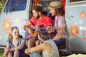 Hipster friends sitting by their camper van