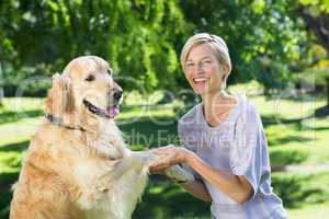 Happy blonde playing with her dog in the park