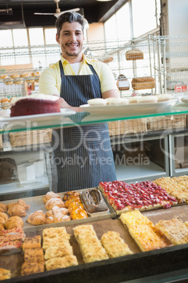 Smiling server standing with arms crossed behind the counter