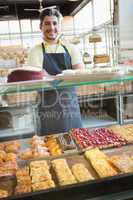 Smiling server standing with arms crossed behind the counter