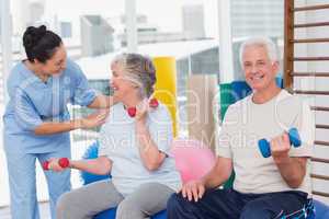 Trainer communicating with senior woman sitting by man