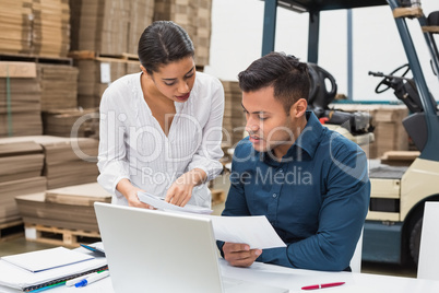 Warehouse managers working with laptop at desk