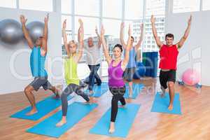 People with hands raised doing yoga