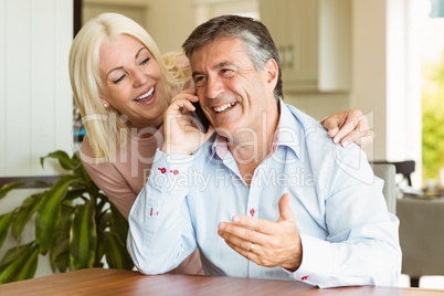 Happy mature couple using smartphone together