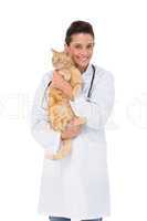 Smiling veterinarian  with a cute kitten in her arms