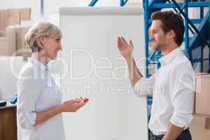 Manager showing something to his colleague on whiteboard