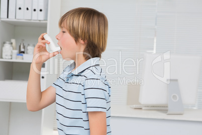 A little boy using inhaler