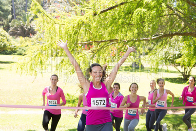 Smiling women running for breast cancer awareness