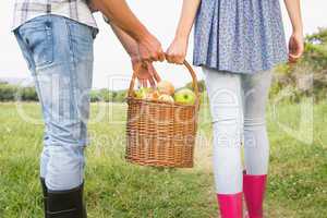 Couple holding basket full of apples