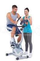 Trainer with client on exercise bike