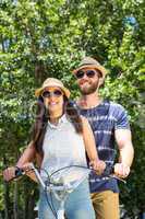 Hipster couple on a bike ride in the park