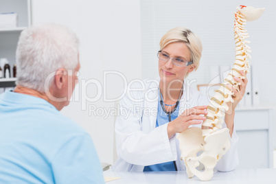 Doctor explaning anatomical spine to male patient