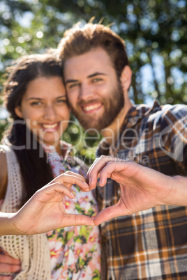 Young couple making heart with hands