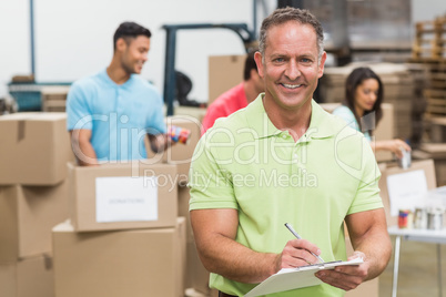 Smiling volunteer man taking notes holding clipboard