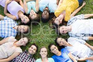 Happy friends in the park lying in circle