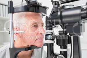 Man looking into slit lamp