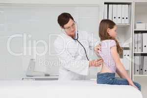 Doctor examining little girl