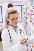 Pharmacist taking medicine from shelf