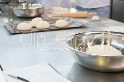 Close up of bowl with dough on worktop