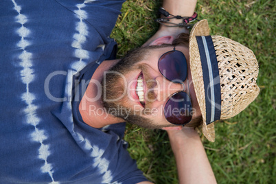 Handsome hipster lying on grass