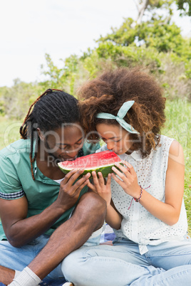 Young couple on a picnic eating watermelon