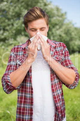 Handsome hipster blowing his nose