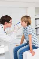 Doctor examines little boy with a light