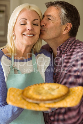 Mature blonde holding fresh pie with husband kissing her