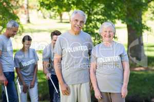 Happy volunteer senior couple smiling at the camera