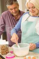 Happy blonde preparing dough with husband