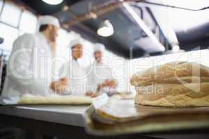 Fresh bread with bakers behind him