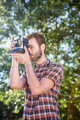 Handsome hipster using vintage camera