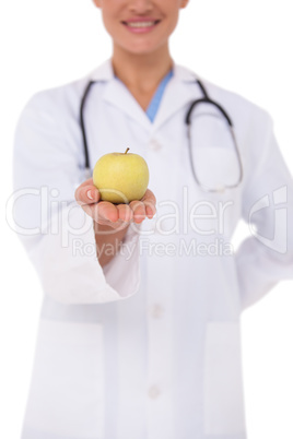 Smiling doctor offering an apple