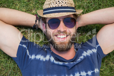 Handsome hipster lying on grass