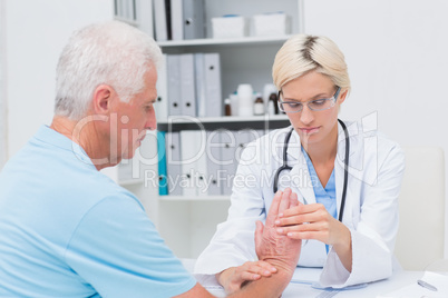 Female physiotherapist examining male patients wrist