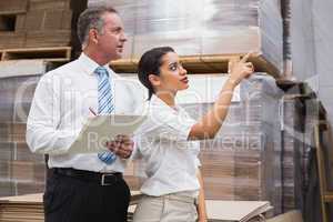Warehouse manager and her boss checking inventory