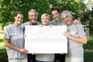 Happy volunteer family holding a blank