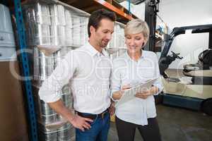 Smiling warehouse managers with clipboard