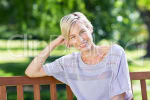 Smiling blonde sitting on a bench