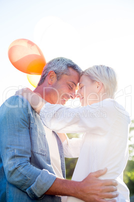 Cute couple holding balloons at the park Cute couple holding balloons at the park